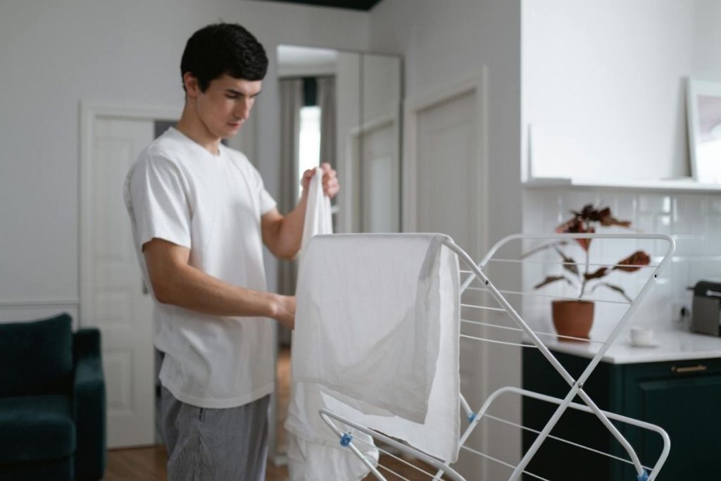 man hanging laundry in house.